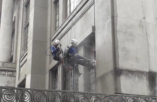 Homens trabalhando na fachada do prédio